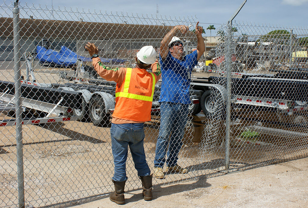 Fence installers installing a hogwire fence