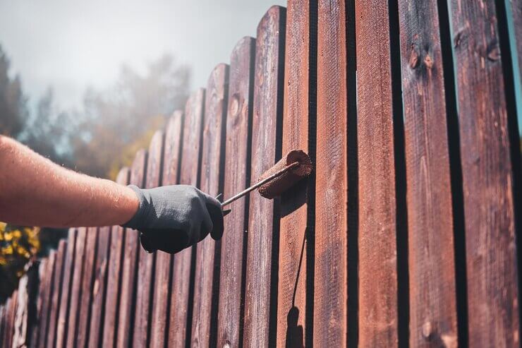 Fence renovation by man in protective gloves.
