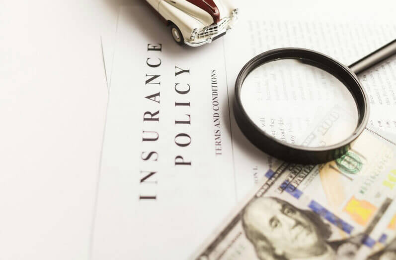 Insurance Policy with a magnifying glass and a dollar bill