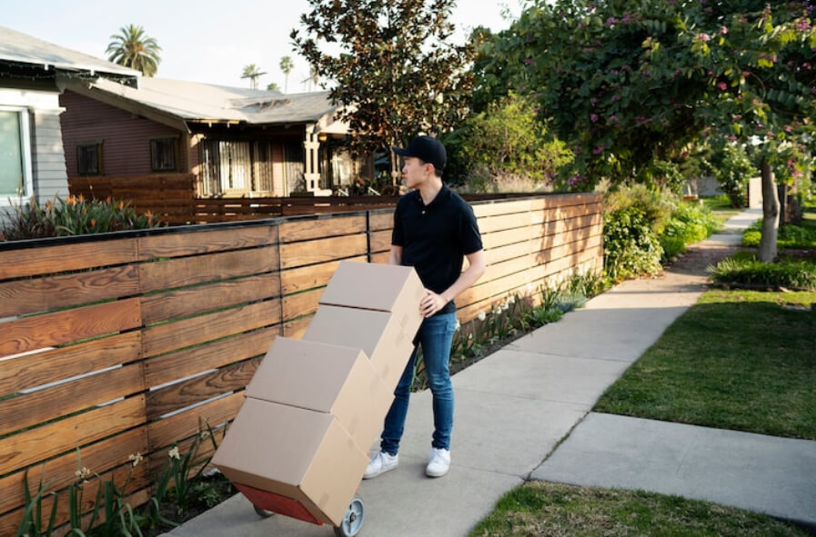 Man delivering parcel outside a beautiful fence 